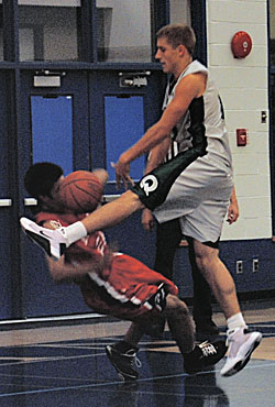bb_oct13_2 First-year guard Omid Davani takes a tumble as a Quest player goes in for a shot during the game, which was described as scrappy by fellow guard Sam Asiedu. (Sandy Buemann photo)