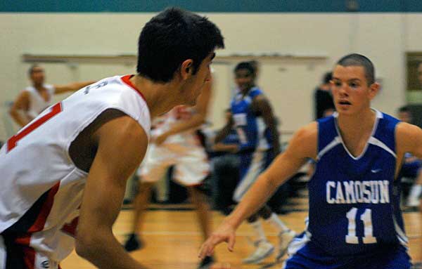 closebball Guard Omid Davani dribbles the ball up the court before being challenged by Kamal Vaid, a forward for the Camosun Chargers.