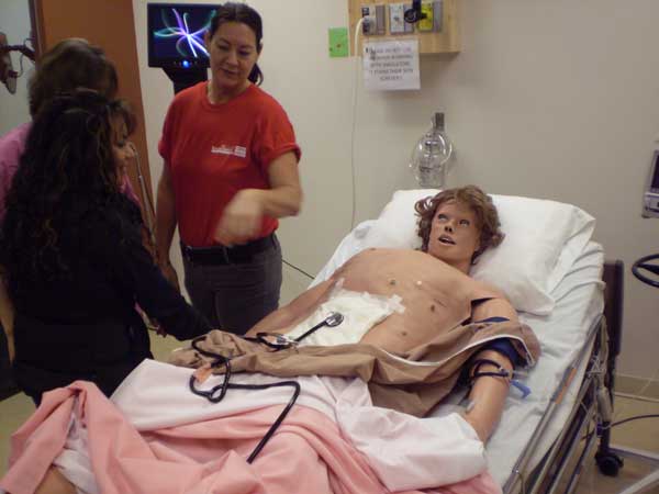 p2270135 Nursing instructors demonstrate one of the robots used to train student nurses. The robots are designed to be as life-like as possible, with a simulated breath, pulse and bowel sounds.