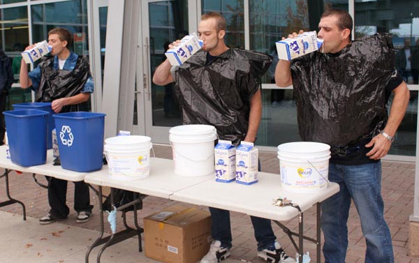 Milk-drinking competition. While drinking milk as fast as they could, Mike Kloeble, Jeremy Johnson and Bryan Barker wore garbage bags to keep from spilling on themselves. (Jacob Zinn photo)