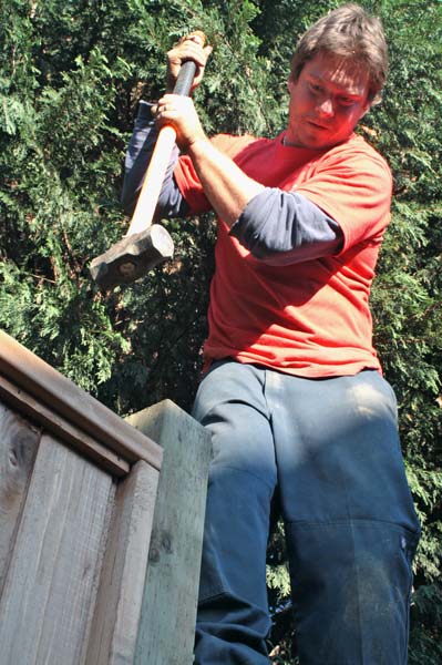sledgehammer Adam Graham lends a hand to the carpenter by hammering the final section of fence into place. (Mitch Thompson photo)