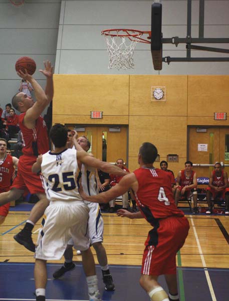 menbb9 Kwantlen's Kenny Ryan (left) goes up for a shot. He was later ejected from the game for hitting a UBCO player under the net.
