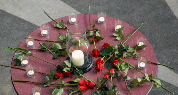 roses Fourteen roses and candles on a tabletop in the Richmond rotunda as a small gathering of students remembered. (Kim Ytsma photo)