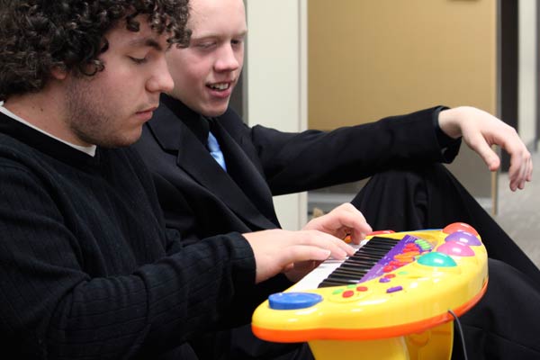 Kyle Poehlke and Laurence Cain have fun playing a Fisher Price toy piano between classes. Alto sax student Laurence Cain, 18, watches guitar student Kyle Poehlke, 21, plays "A Thousand Miles" by Vanessa Carlton on a vintage Fisher Price toy piano. (Jacob Zinn photo)