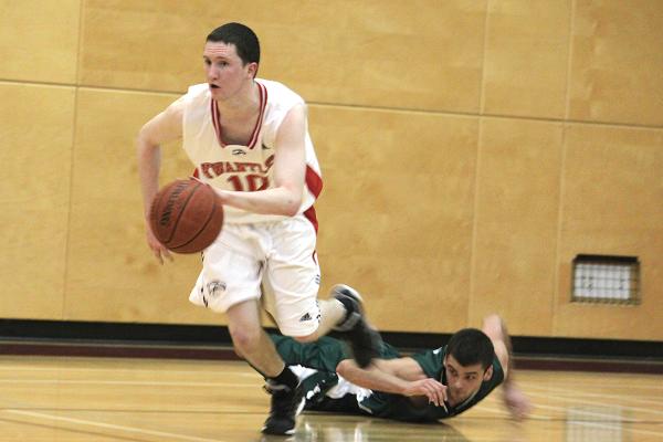 Doug Meyers retrieves the stray basketball from Brad Quevillon, who dove for it in an attempted turnover. (Jacob Zinn photo) Doug Meyers retrieves the stray basketball from Brad Quevillon, who dove for it in an attempted turnover.
